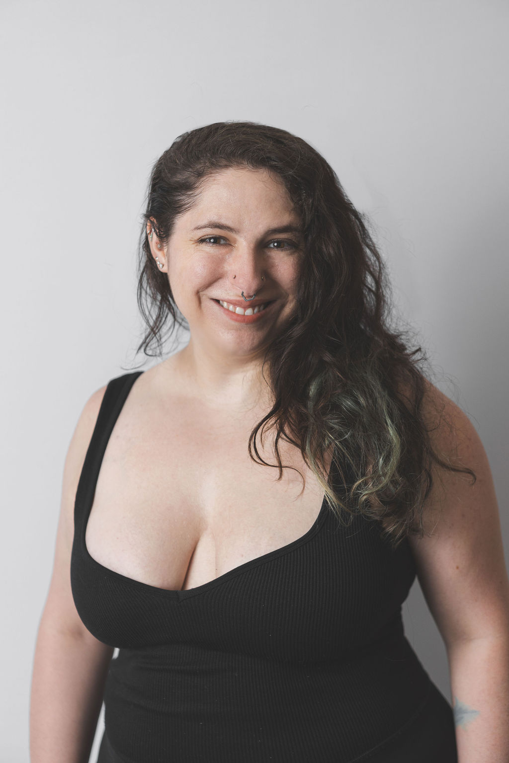 Smiling Be Fitness instructor wearing black top against neutral background