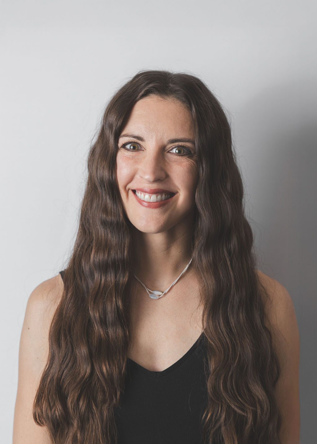 Smiling Be Fitness instructor wearing black top against neutral background