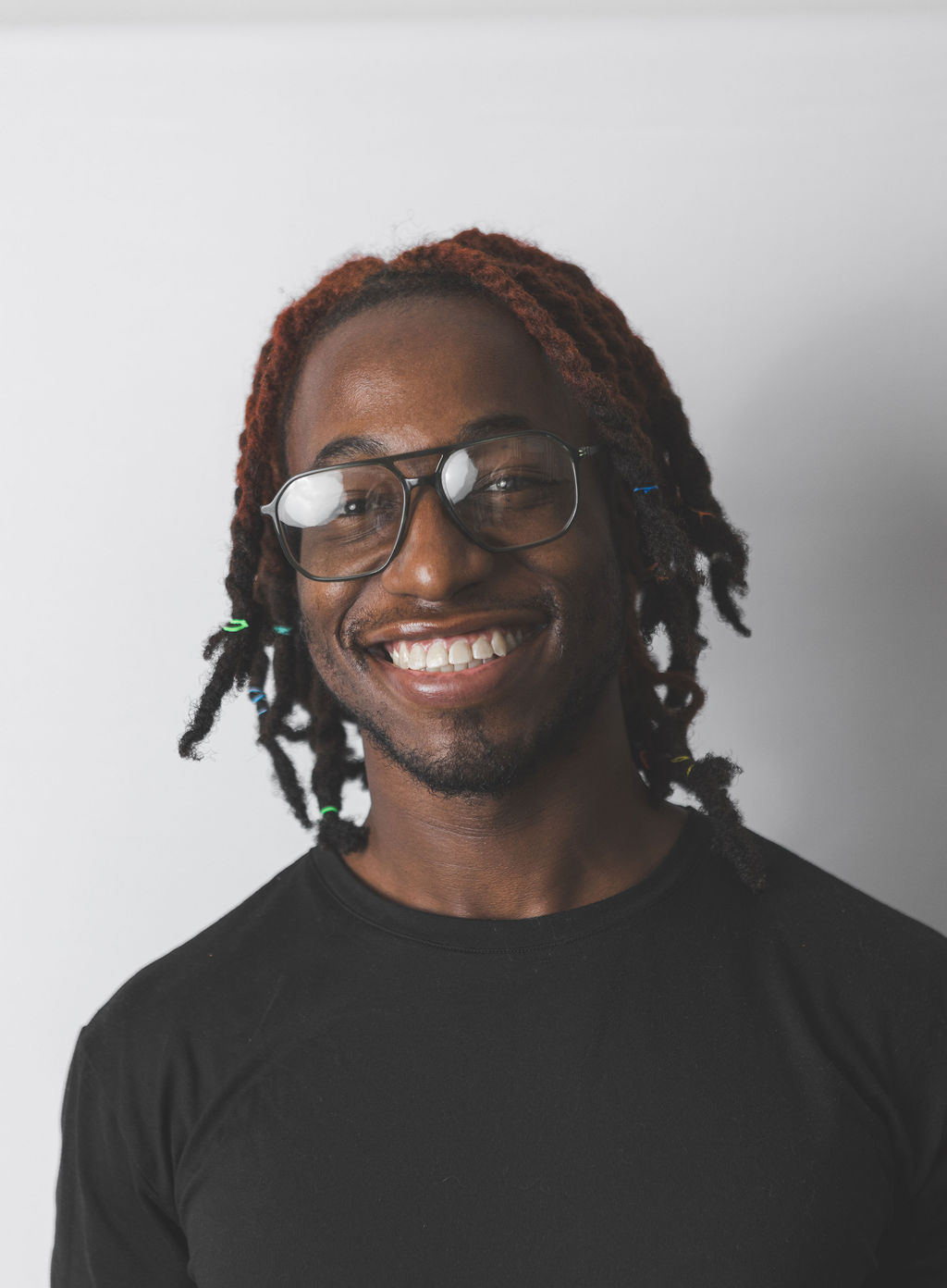 Smiling Be Fitness instructor wearing black top against neutral background