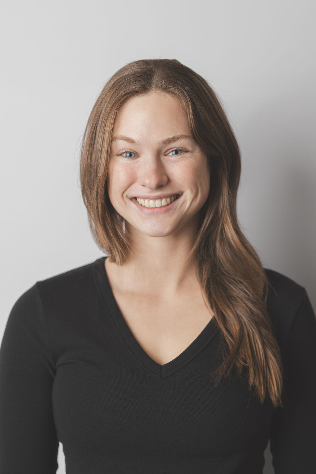 Smiling Be Fitness instructor wearing black top against neutral background
