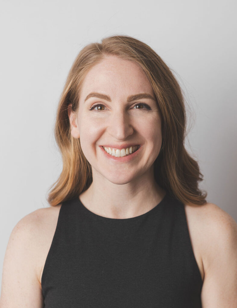 Smiling Be Fitness instructor wearing black top against neutral background