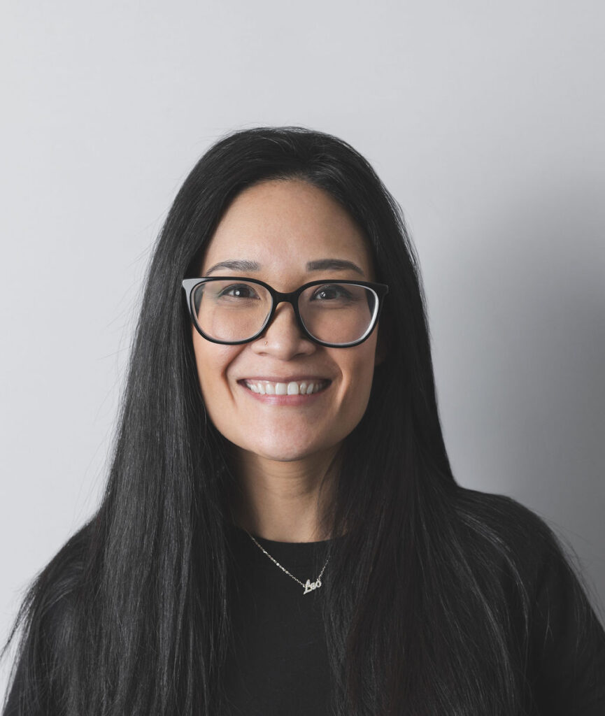 Smiling Be Fitness instructor wearing black top against neutral background