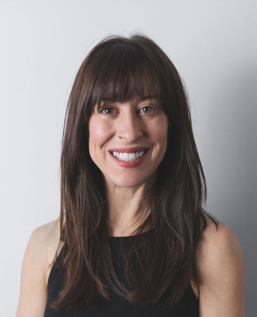 Smiling Be Fitness instructor wearing black top against neutral background