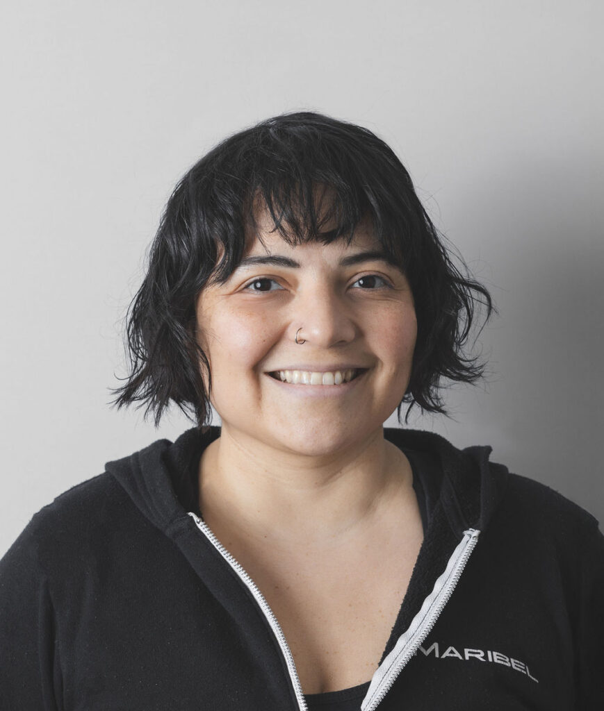 Smiling Be Fitness instructor wearing black top against neutral background